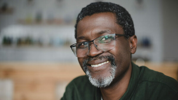 Older african american man with glasses and gray beard smiling