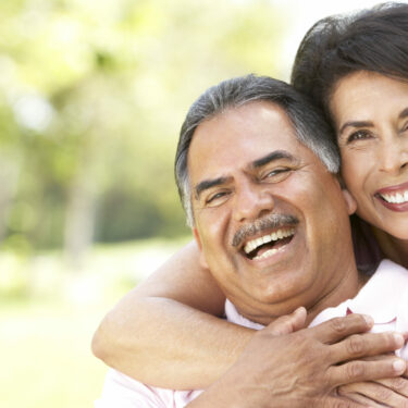 Senior couple smiling and posing in a park