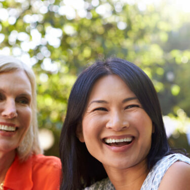 Women smiling outside Mullins SC dental implant dentist