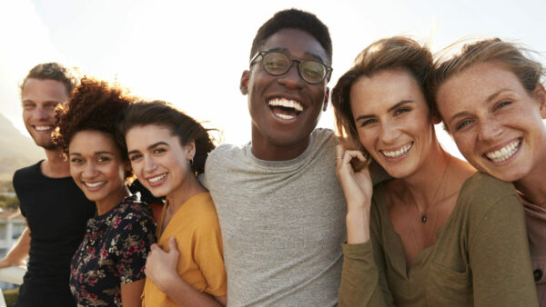 Portrait Of Smiling Young Friends Walking Outdoors Together